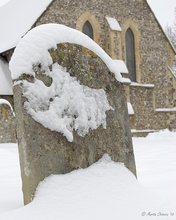 Snow-Covered Gravestone and Church